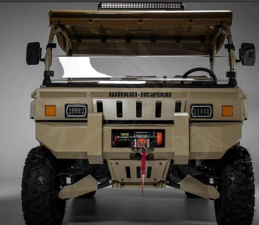 Steering wheel and beige dashboard of a heavy-duty vehicle with numerous switches in view.